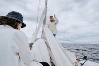 Man in White Thobe and Black Cap Sitting on Boat