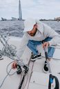 Man in Gray Long Sleeve Shirt and Blue Denim Jeans Sitting on White Boat