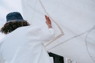 Person in White Long Sleeve Shirt Standing on White Sand