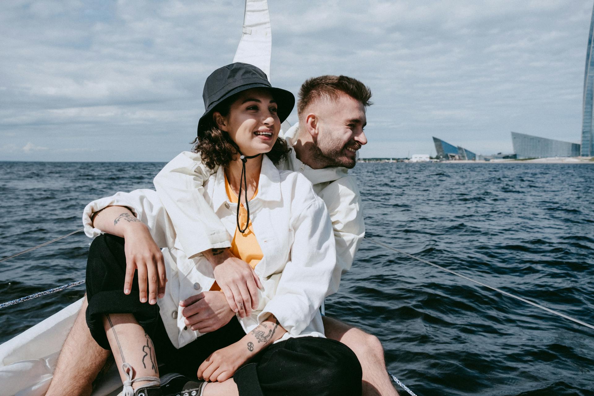 A young couple enjoying a leisurely yacht ride on open waters, embracing a romantic adventure.