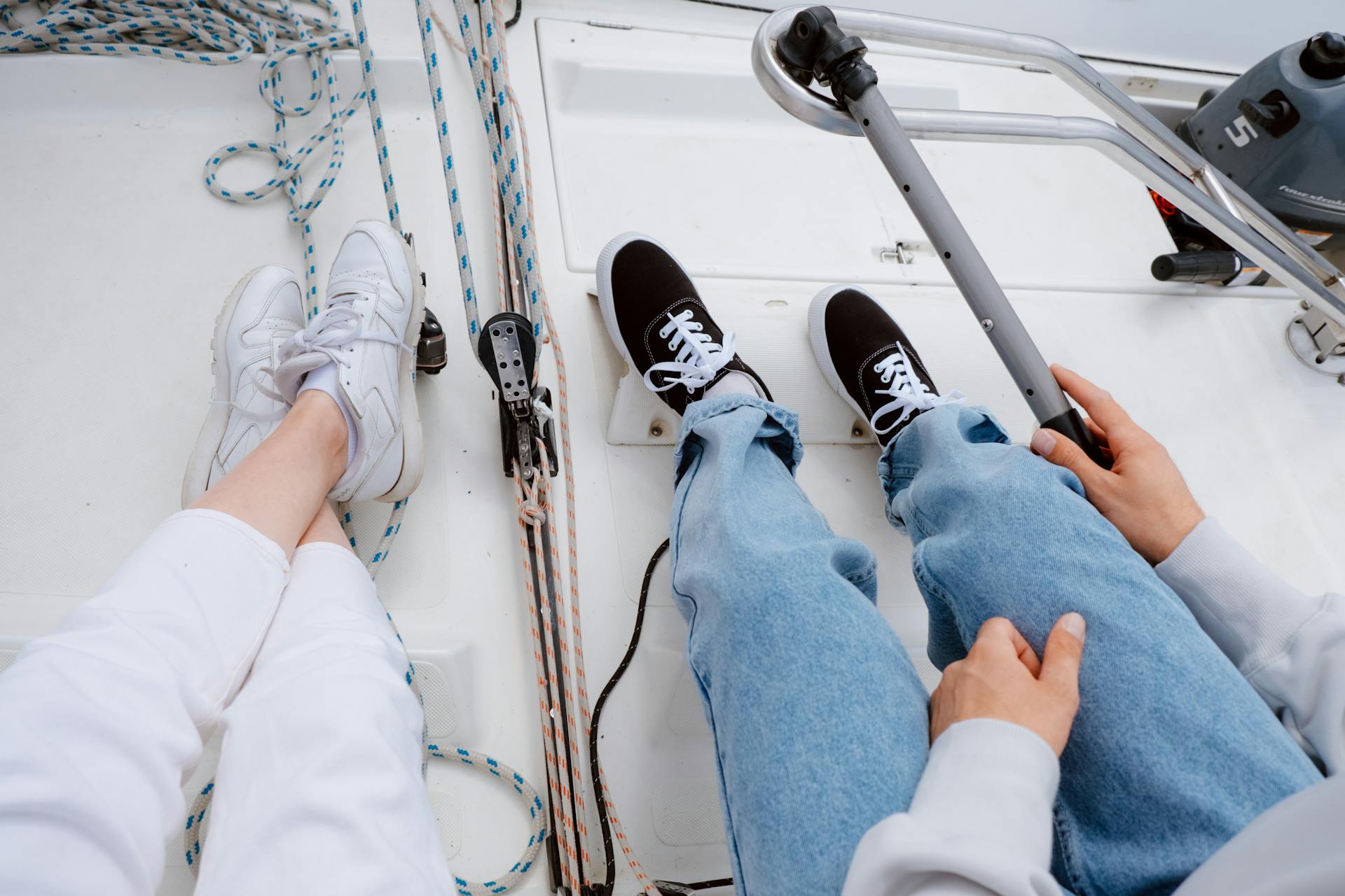 Two people relaxing on a yacht deck, capturing a serene sailing experience on the open sea.