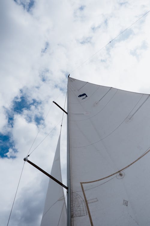 Velero Blanco Sobre El Agua Bajo Un Cielo Azul Y Nubes Blancas