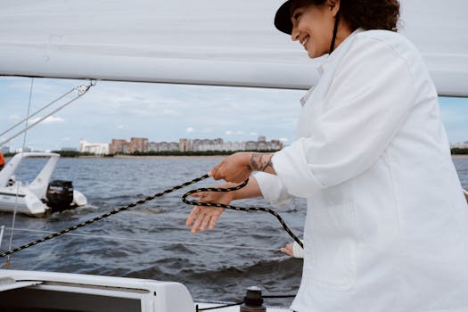 Smiling woman sailing on a yacht, enjoying a sunny day on the water.