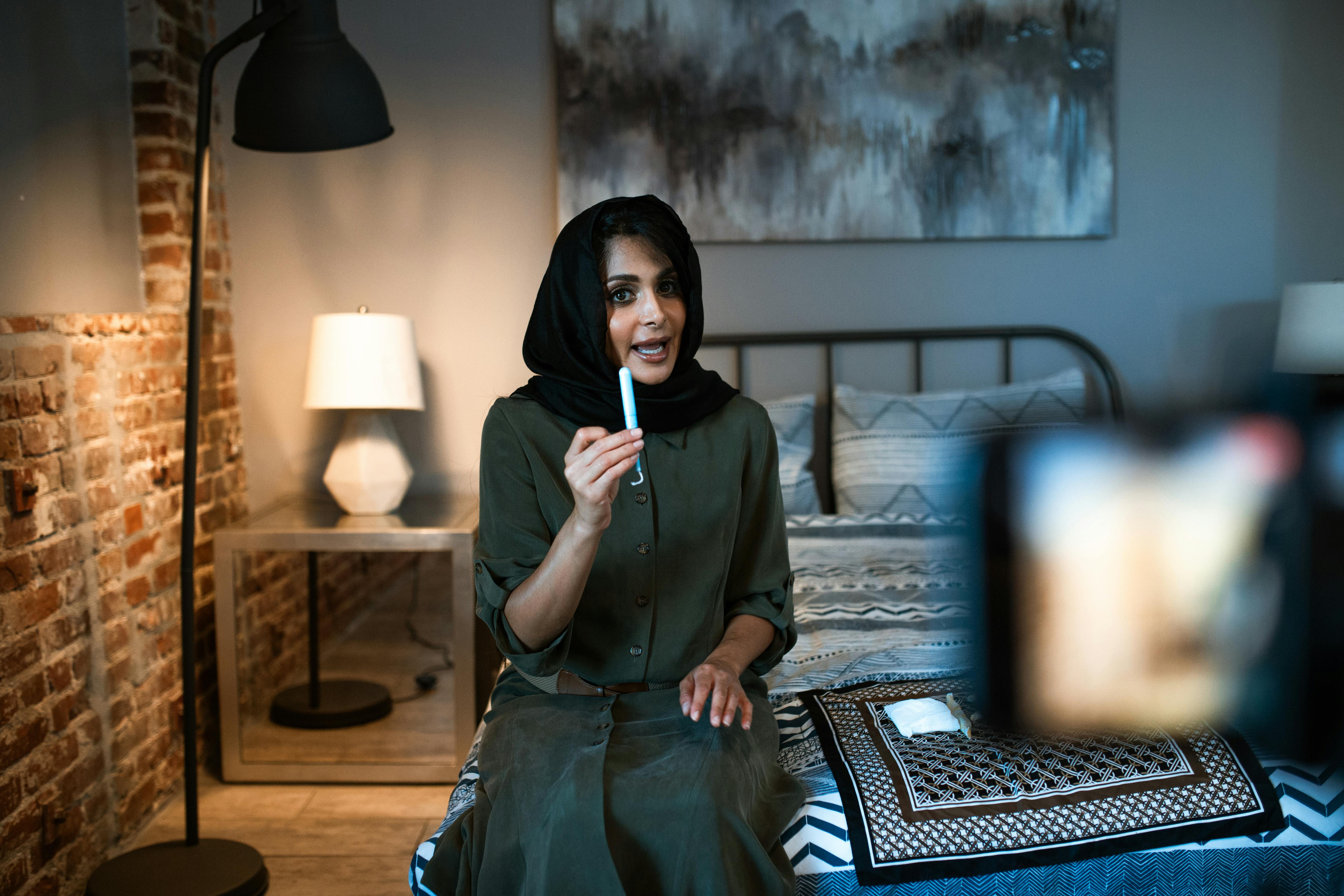 woman in a hijab holding a tampon