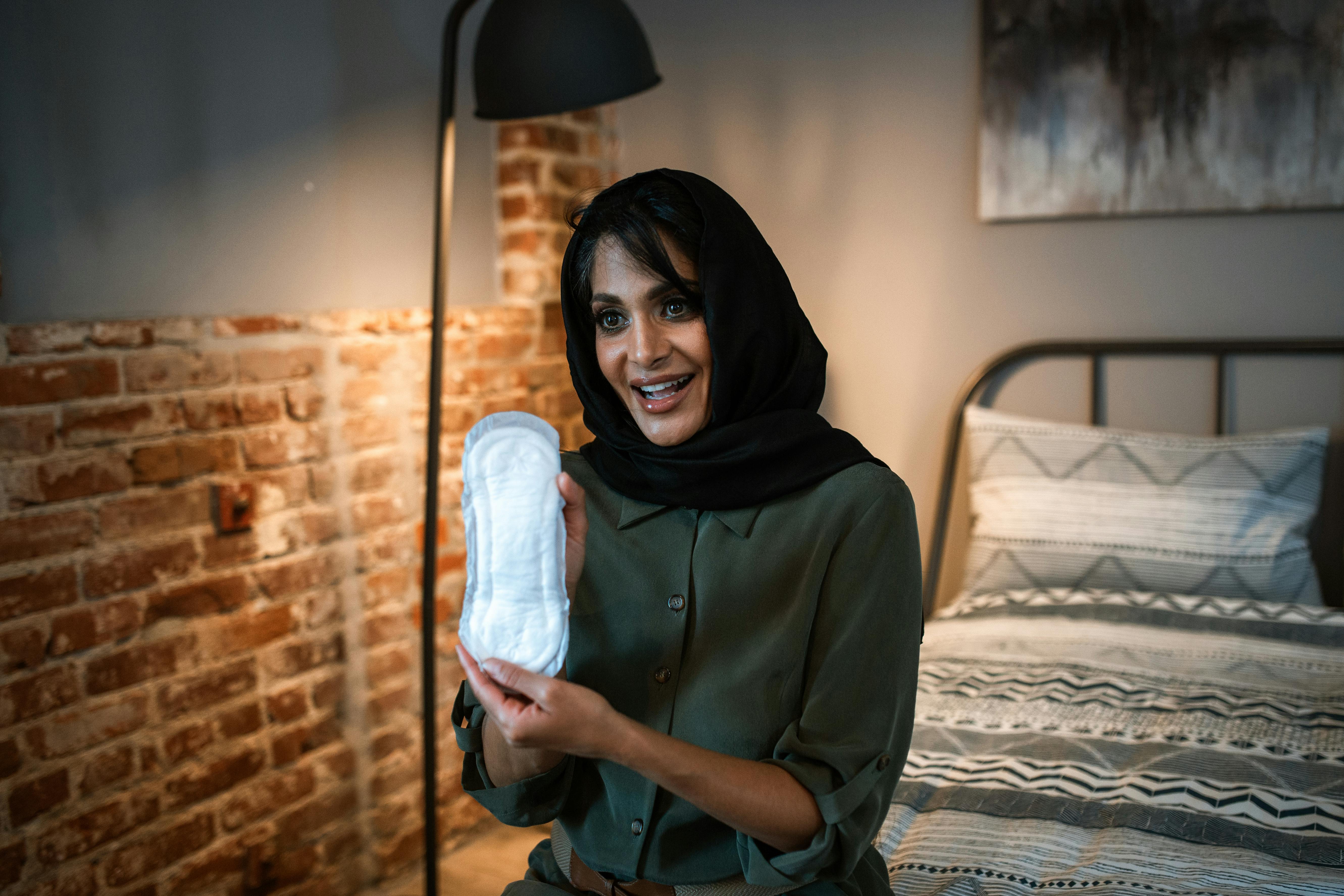 woman in a hijab holding a sanitary pad