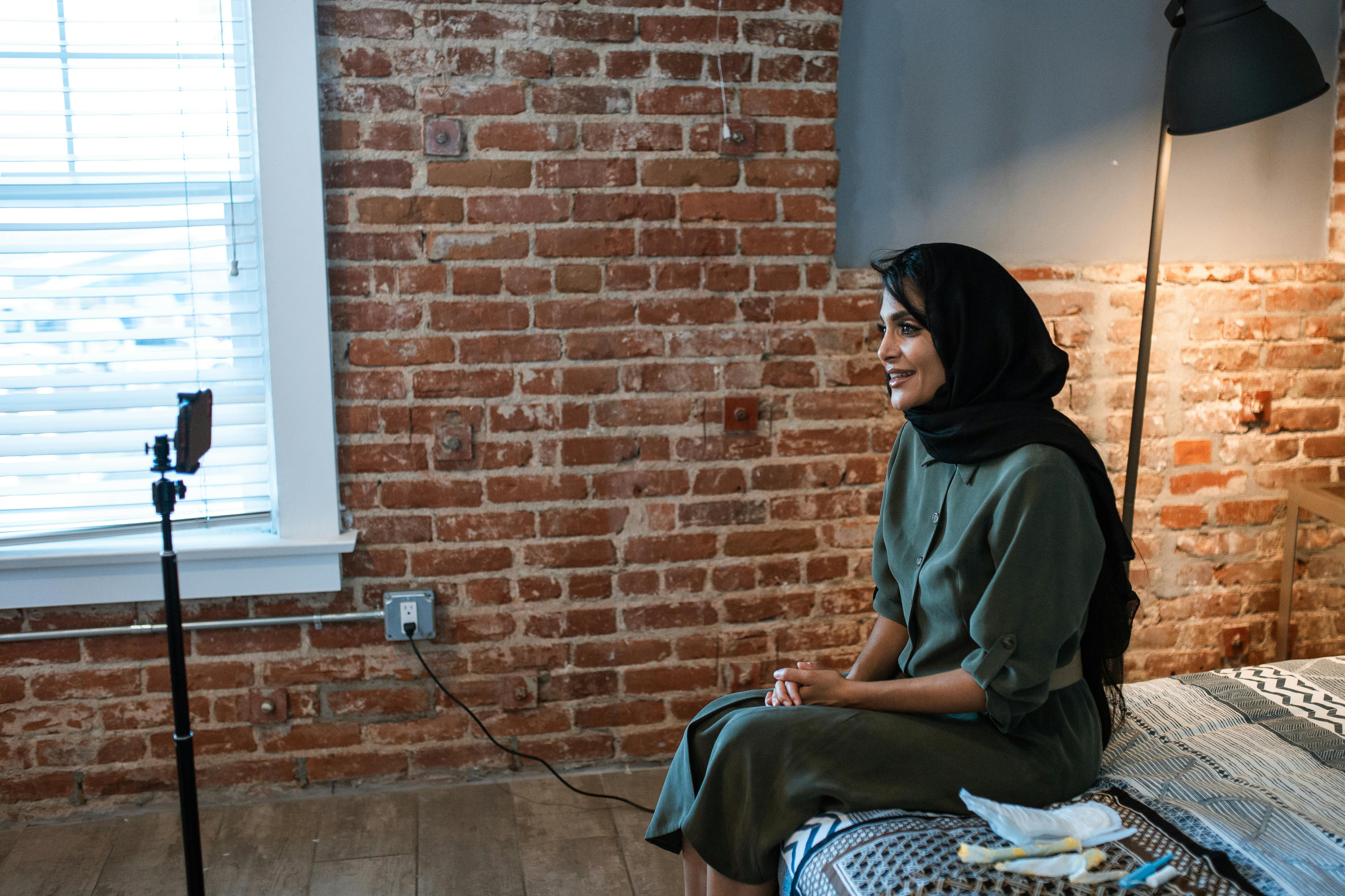 woman in a hijab sitting on a bed