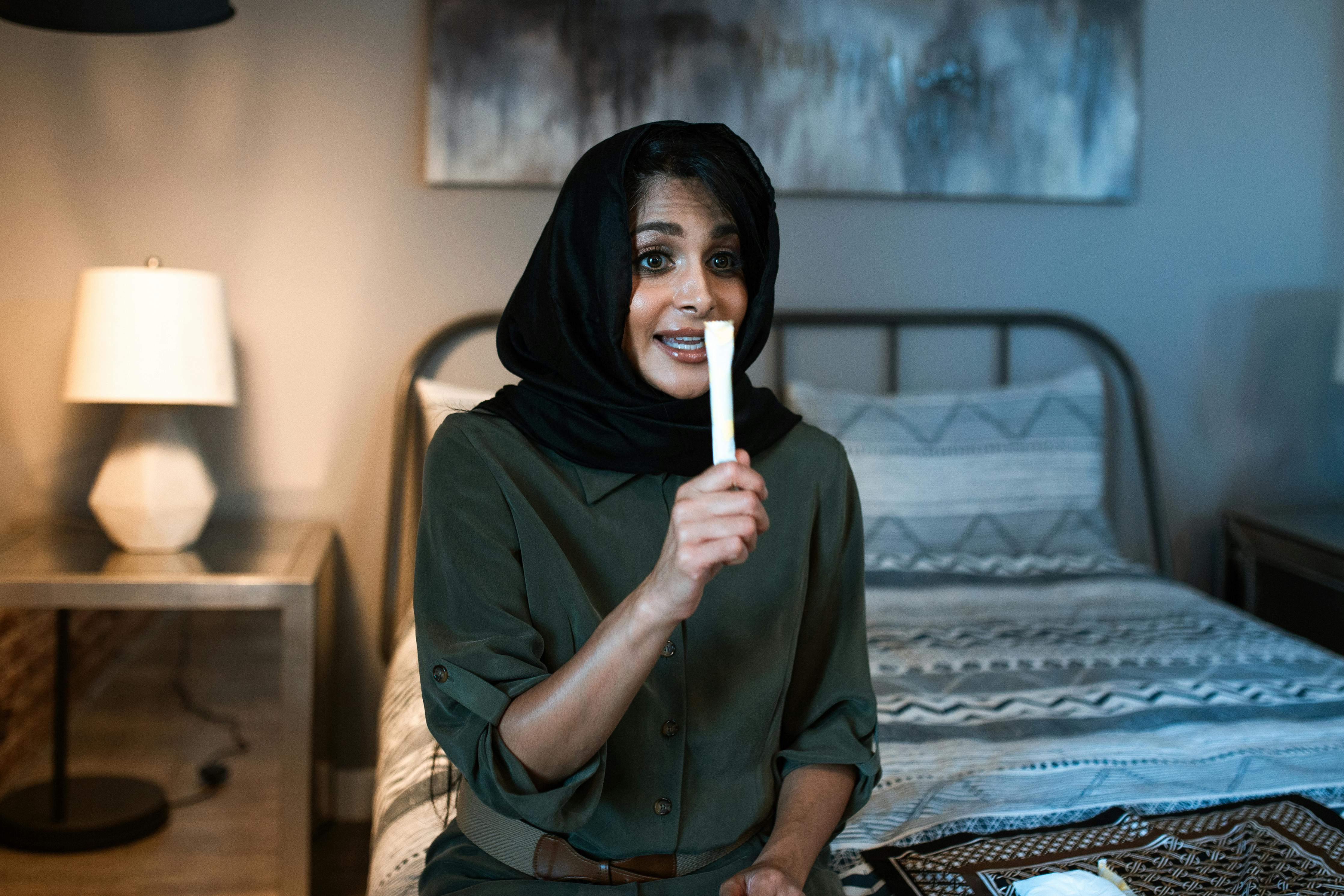 woman in a hijab holding a tampon