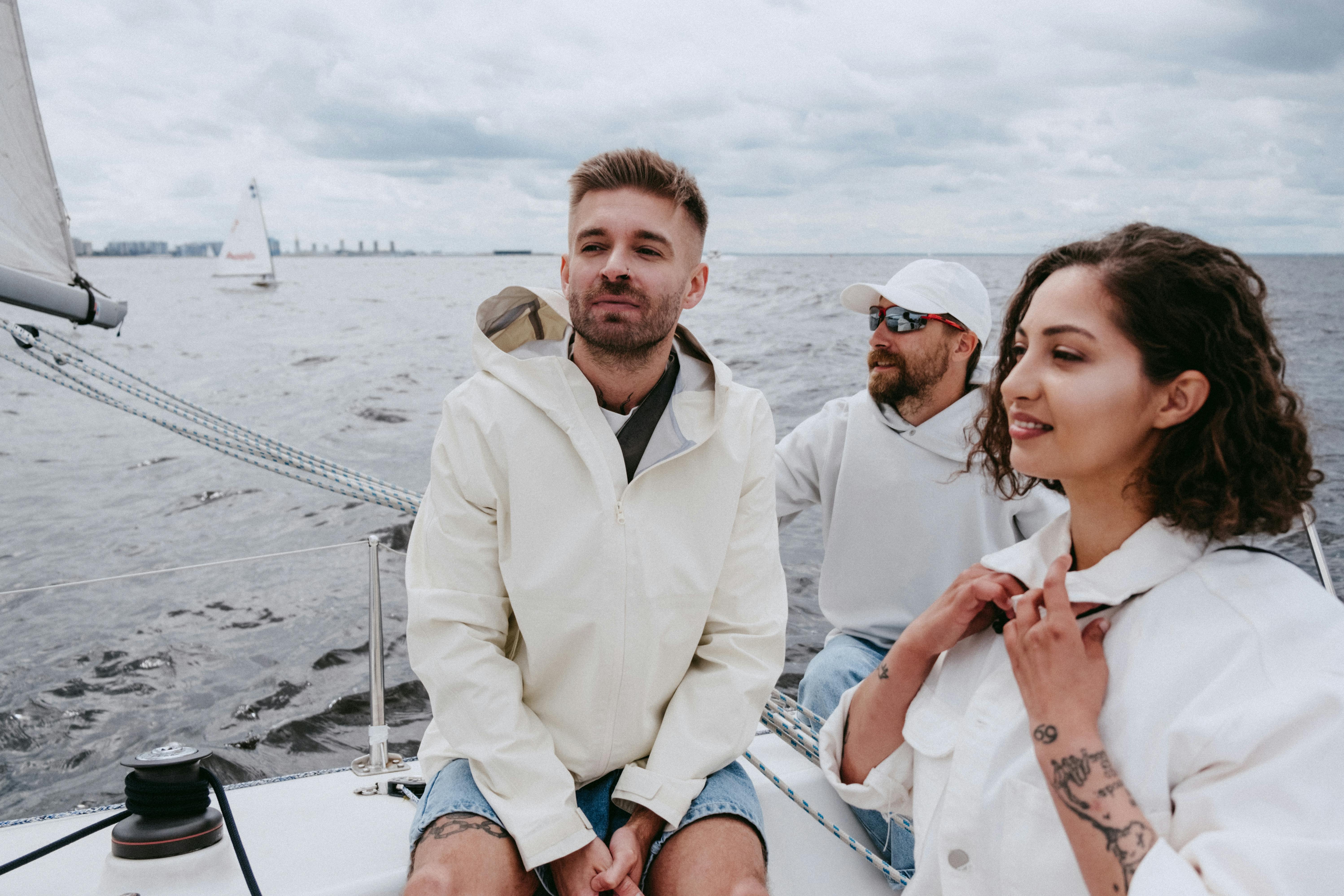 Three friends sailing on a yacht, enjoying a leisurely adventure on open sea waters.