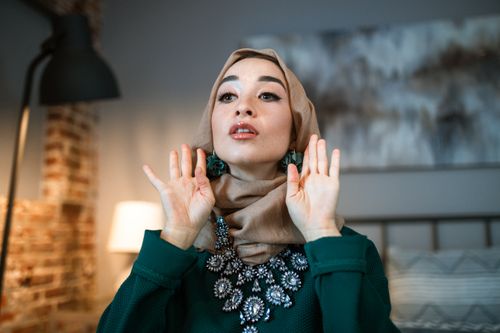 Free A stylish woman in a hijab poses indoors with elegant decor in the background. Stock Photo