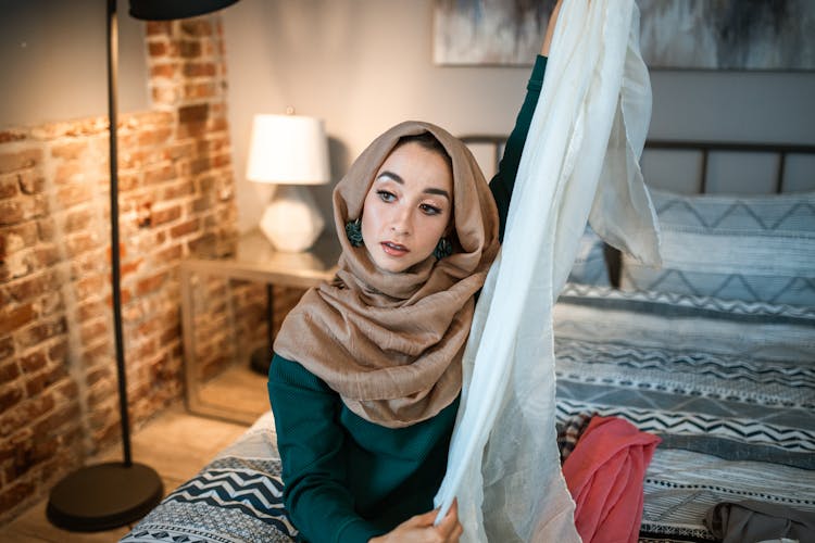 Woman In Brown Hijab Holding A White Sheer Textile 