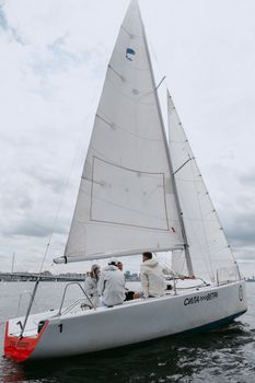 帆船赛期间，船员们在城市天际线附近的游艇上行动