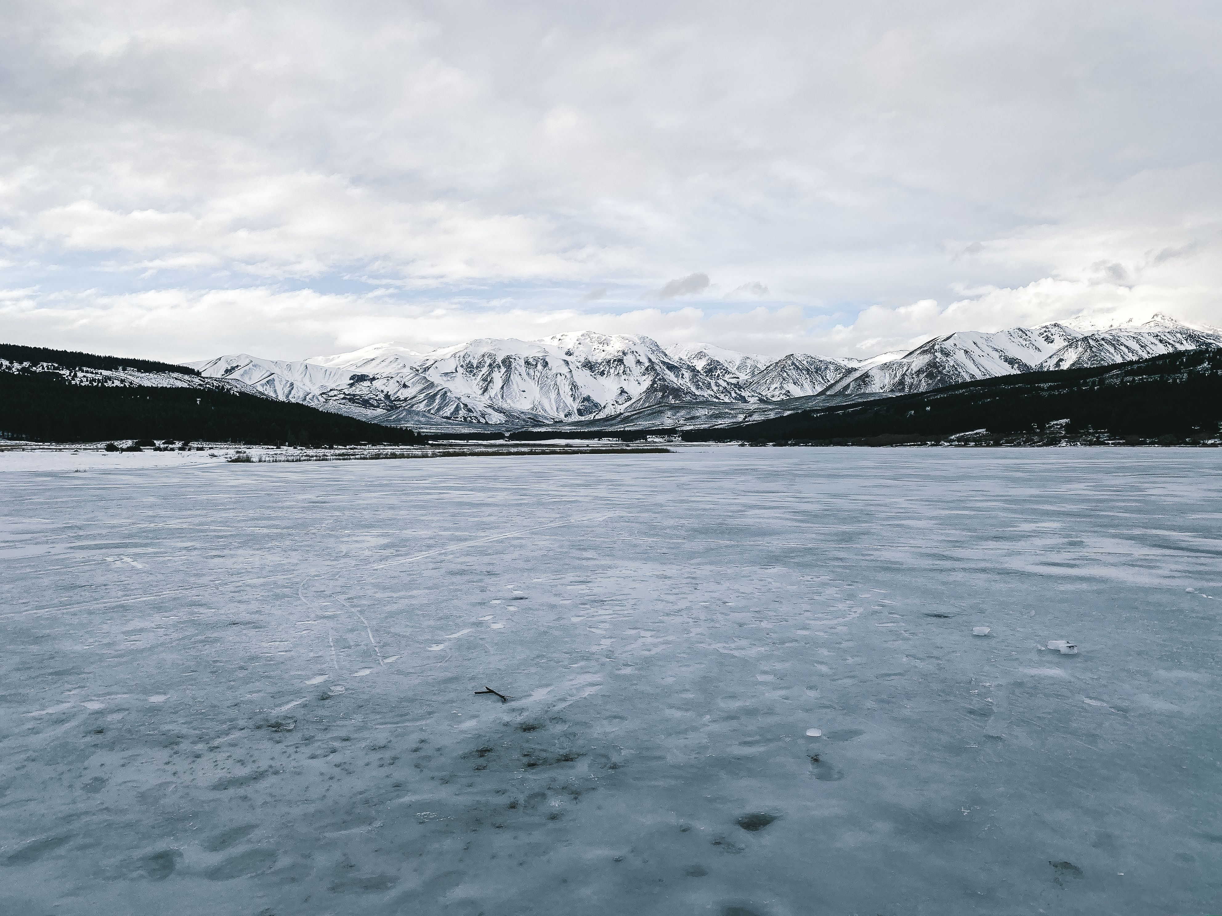 Stunning view of snow-covered mountains and a frozen lake in Esquel, Chubut, Argentina.