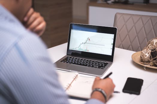 A person analyzes cryptocurrency data on a laptop during remote work from a home office.