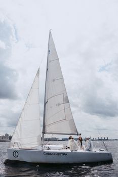 People on White Sail Boat Under Cloudy Sky