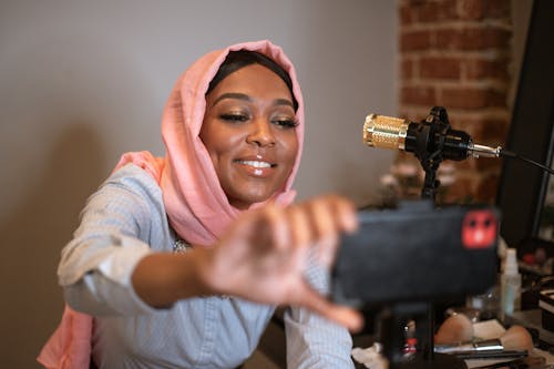 흰색 긴 소매 셔츠와 주황색 Hijab에 웃는 여자