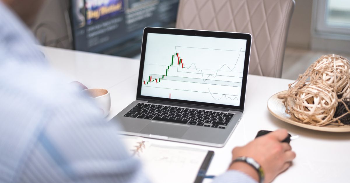 A trader analysing chart indicators on a laptop