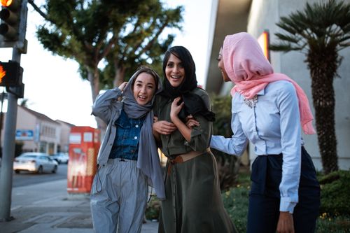 Free Three diverse women in hijabs smiling and enjoying each other's company outdoors, showcasing cultural diversity and friendship. Stock Photo