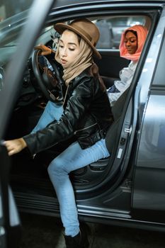 车里有两名年轻女子，其中驾驶座上的那位戴着头巾