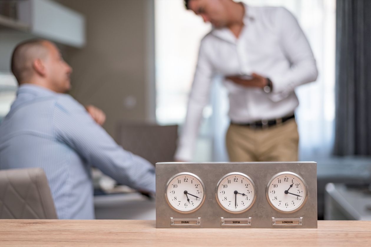 Businessmen in an office with world clocks