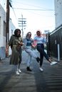三名戴着头巾的妇女在小巷里无忧无虑地享受着时光