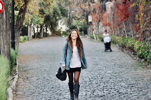 Beautiful Woman in Denim Jacket walking on a Park 