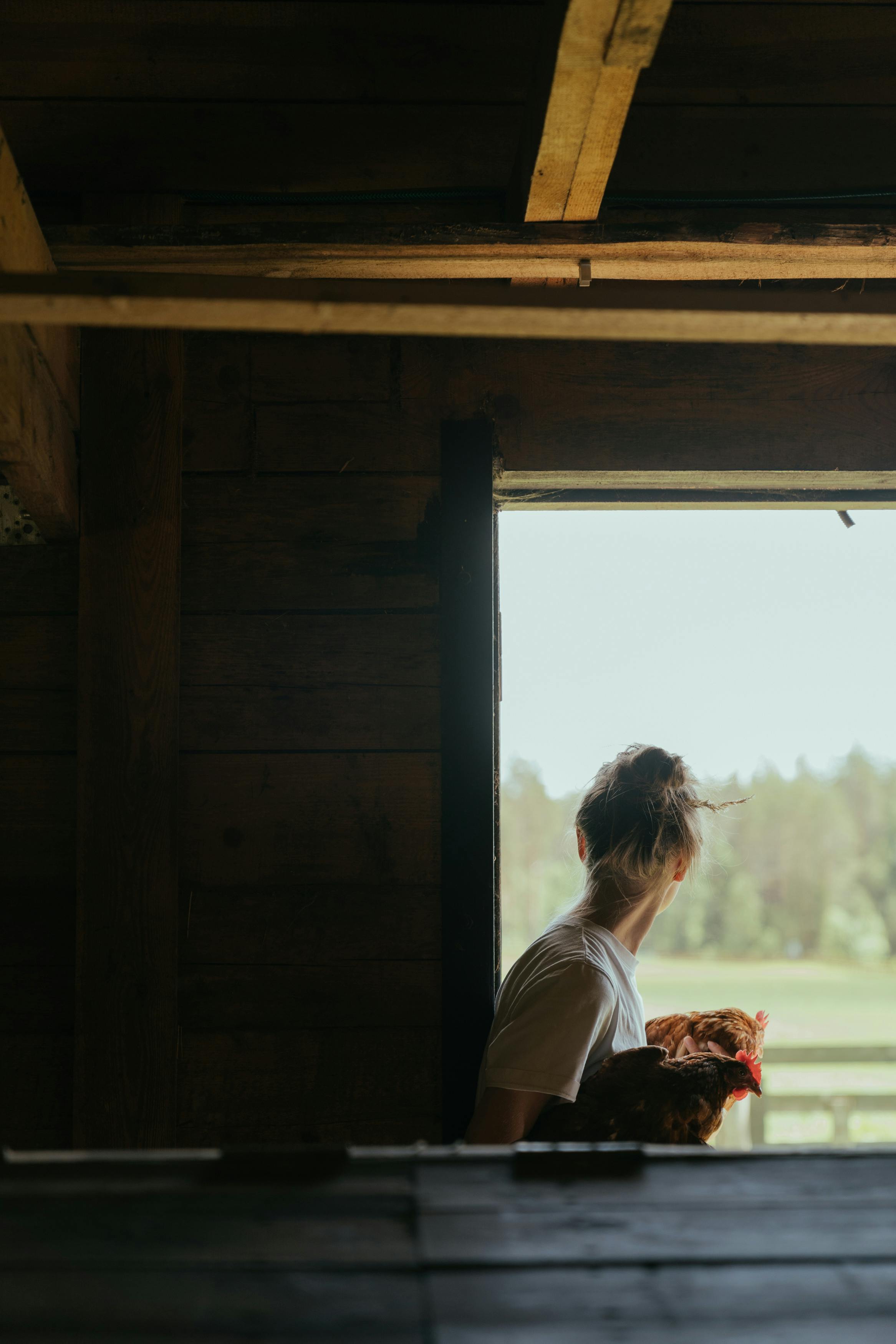 woman in white shirt looking at the window