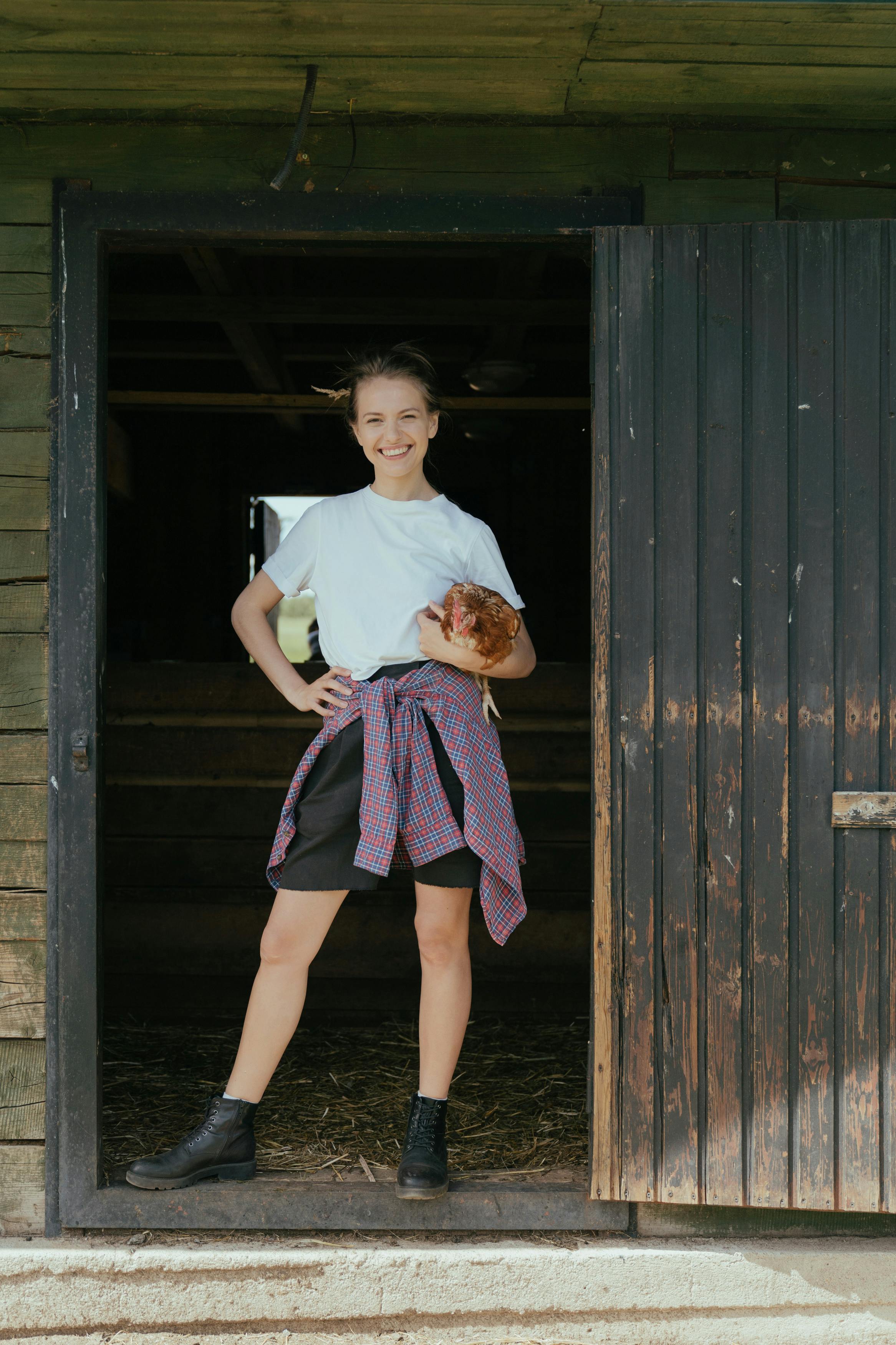 woman in white crew neck t shirt and purple skirt standing beside brown wooden wall