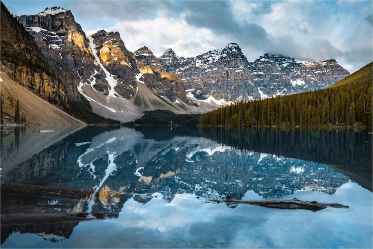 Clean Lake Near Snow Mountains And Forest