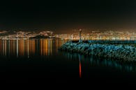 Beacon near ocean and mountains with bright lights