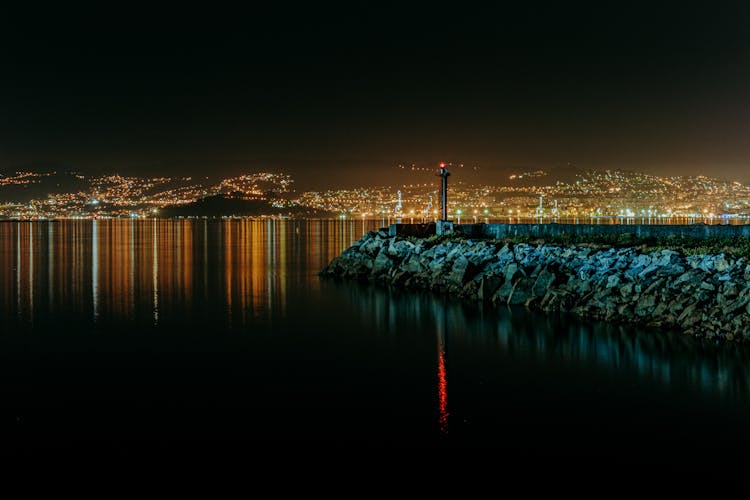 Beacon Near Ocean And Mountains With Bright Lights