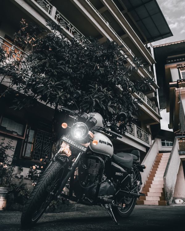 Free A Royal Enfield motorcycle parked outdoors with architectural backdrop. Stock Photo