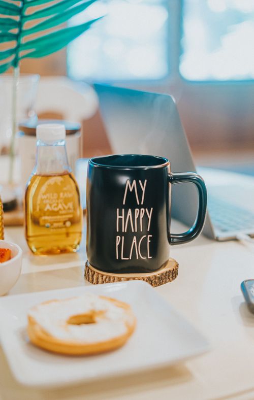 Free Sweet doughnut and cup of hot drink placed on table during breakfast in morning at home Stock Photo