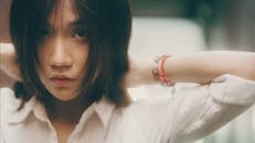 Young ethnic woman touching hair