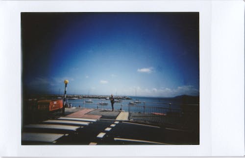 Instant Photo of Person Standing by the Dock