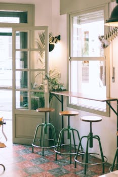 咖啡馆内部轻松自然，光线充足，配有复古凳和绿色植物
