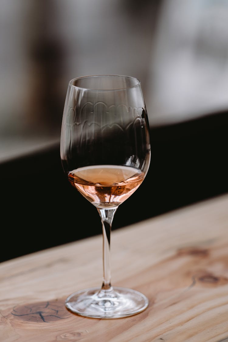 Glass Of Wine Served On Wooden Counter In Restaurant