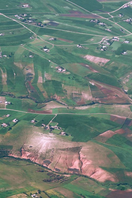 Free Drone view of small settlement with houses located on agricultural terrain in rural area on  sunny summer day in nature Stock Photo