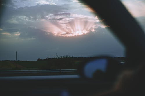 Car riding through field in evening