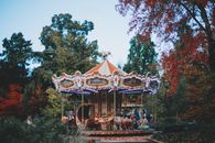绿树成荫的公园里，充满活力的旋转木马营造出节日而有趣的氛围