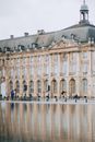 Old building facade reflecting in urban river in city