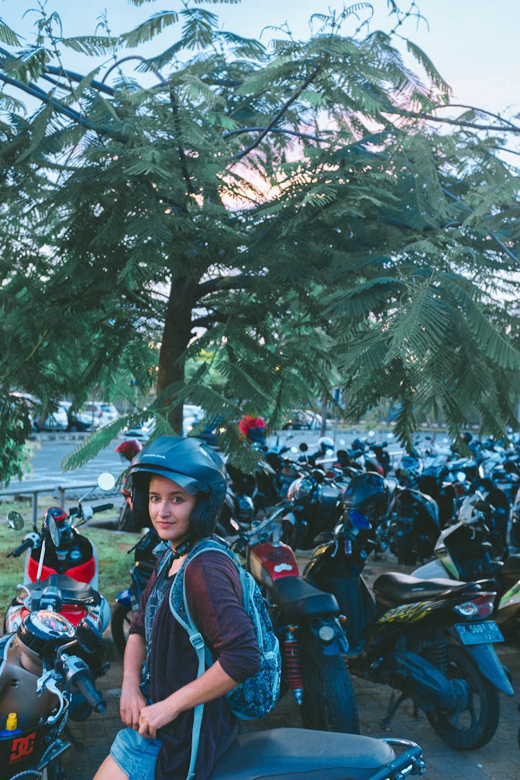 Teen In Protective Helmet Resting On Motorbike