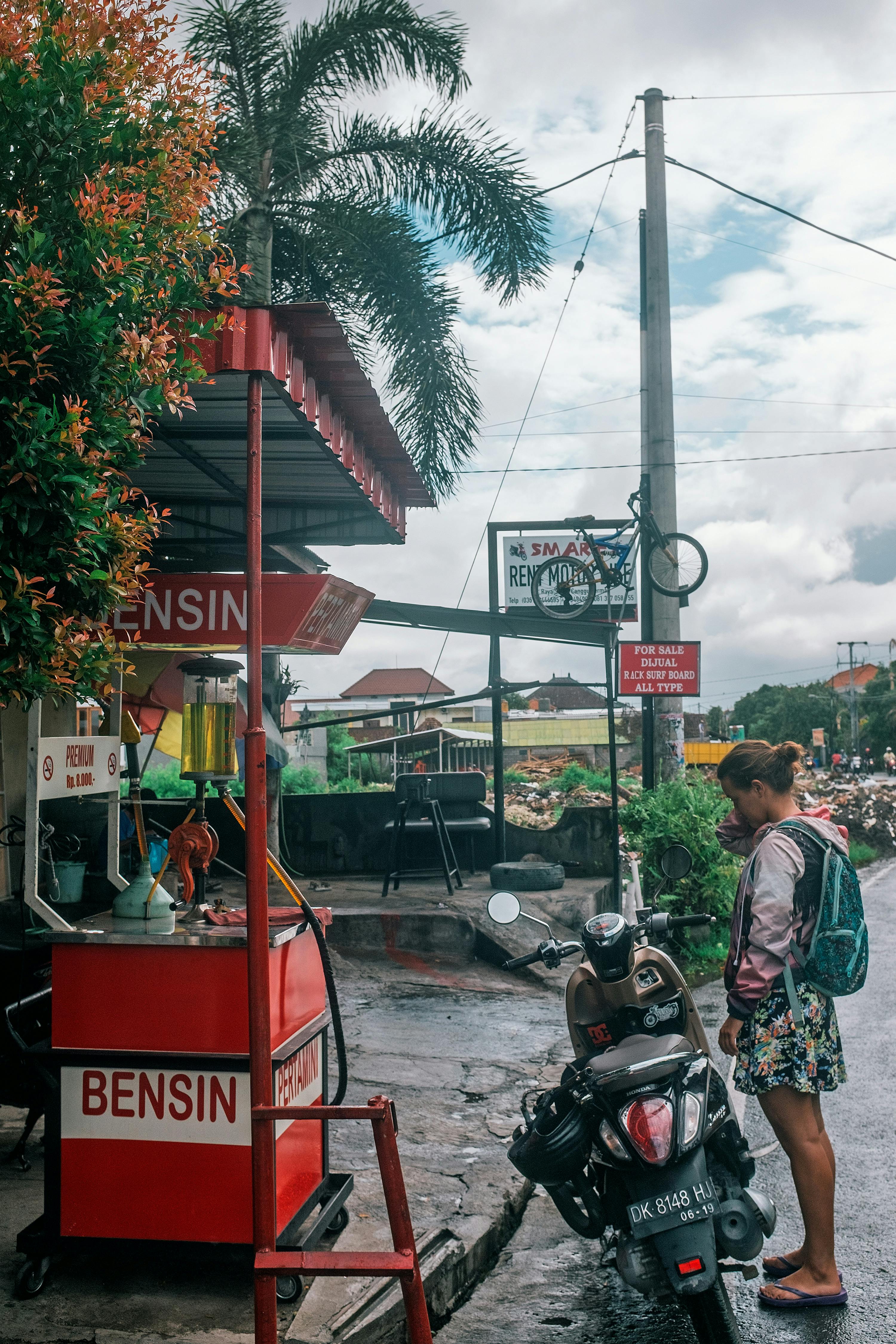 woman with motorbike at gas station