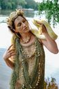 Fashionable young pregnant woman with reticulated python on shoulders