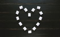 Marshmallow set in form of heart on black wooden table