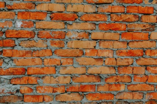 Free Textured background of rough aged brick wall with small cracks built with cement Stock Photo