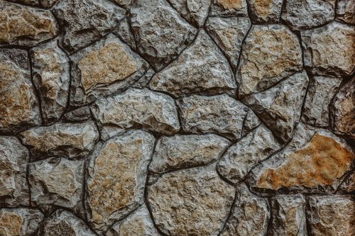 Free Textured background of rough shabby stone wall with cracks between boulders of different shapes Stock Photo