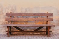 Wooden bench against dirty stone wall