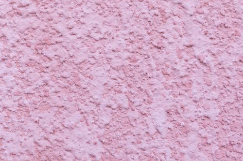 Minimalist background of pink colored wall covered with decorative fine plaster of building