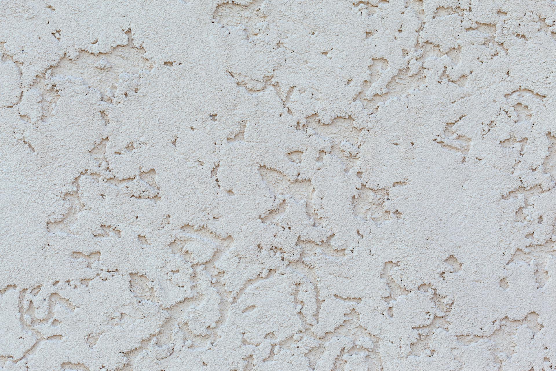 Detailed close-up of a textured white plaster wall surface, perfect for backgrounds or design elements.