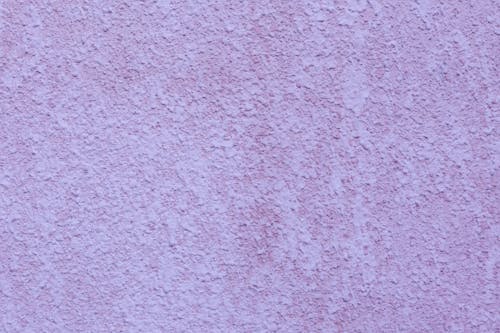 Background of facade wall covered with bright purple decorative plaster making texture and relief